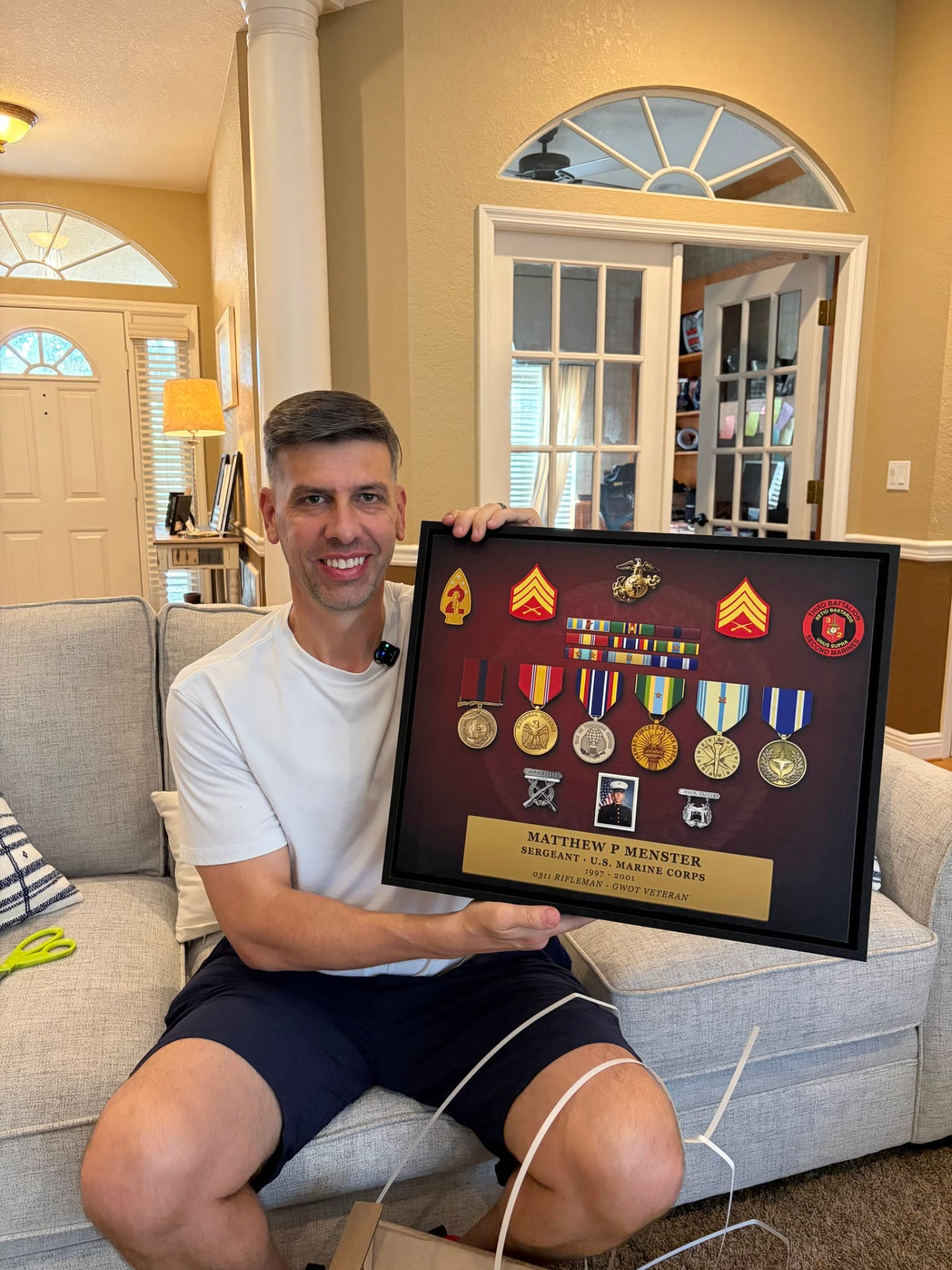Founder Matt Menster holding his finished framed Valor Canvas of U.S. Marine Corps medals and ribbons