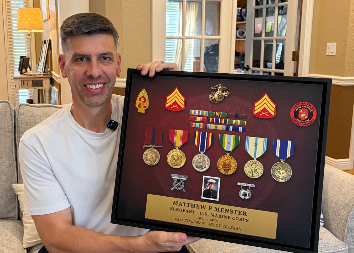 Matt Menster, USMC veteran and Valor Block founder, holding his framed 20×16 Valor Canvas™ at home